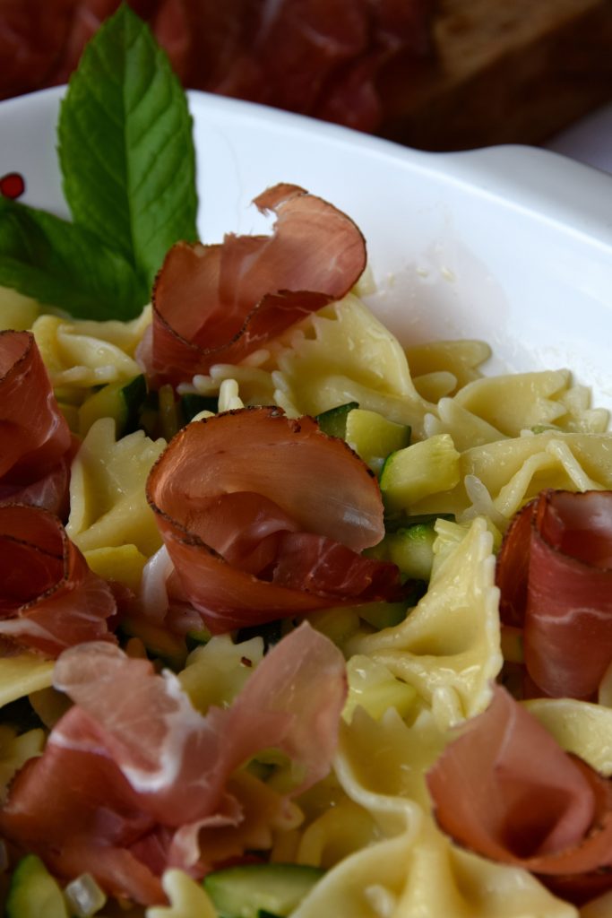 Farfalle condite con zucchine, menta fresca e speck